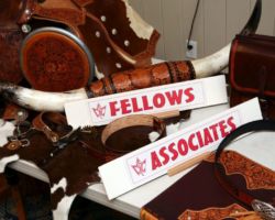 Tooled leather work, ribbons and Fellows and Associates award cards on the display table at the 2019 convention