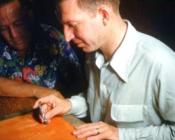 Two craftsmen tooling leather at a workbench, from the Society's early photo archive