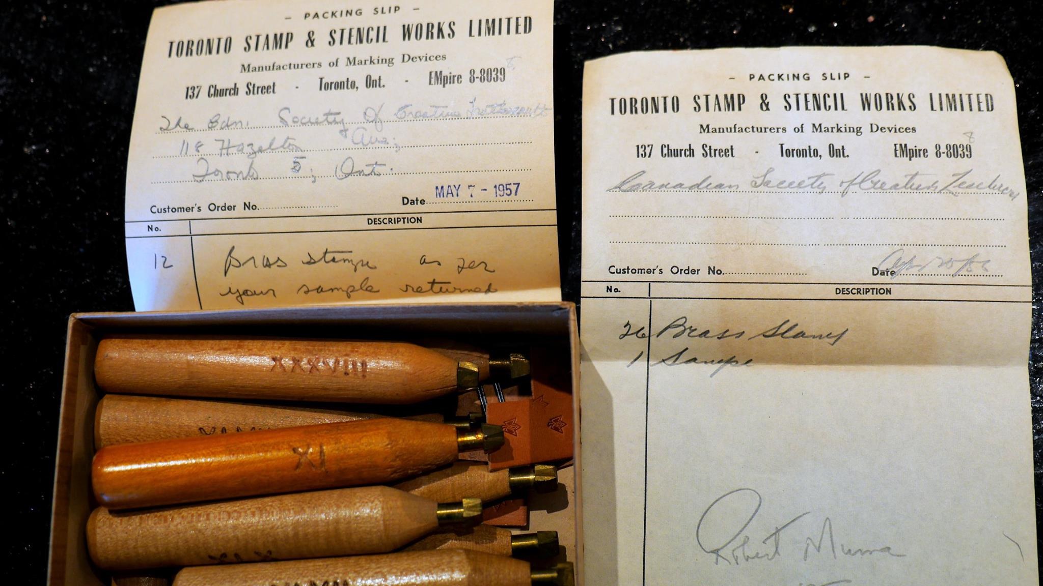 Two packing slips from Toronto Stamp & Stencil Works Limited, 137 Church Street, Toronto, beside a box of stamps whose handles carry Roman numerals, among them XXXVIII.