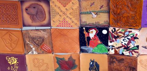 A patchwork of square leather tiles, tooled and painted with a dog, a wizard, a maple leaf and Celtic knots
