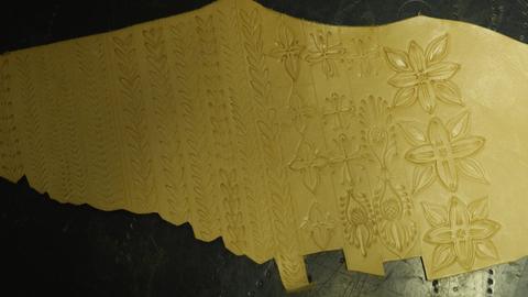 A tooled floral border with a scalloped edge