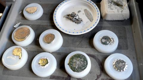 Silicone moulds on a tray, pewter castings still in some of them