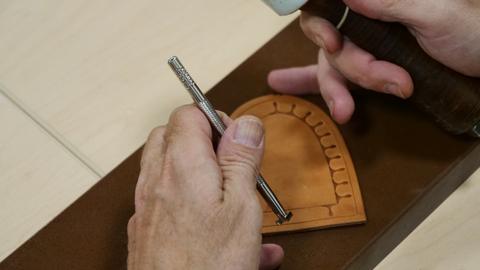 A stamped coaster under the tool